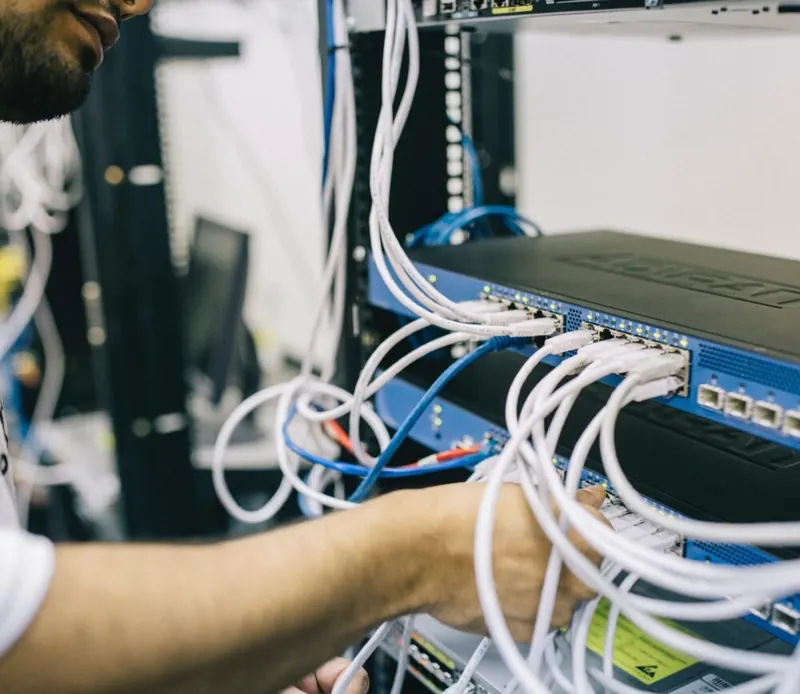 Ingeniero de Multitek conectando cableado en un rack de red