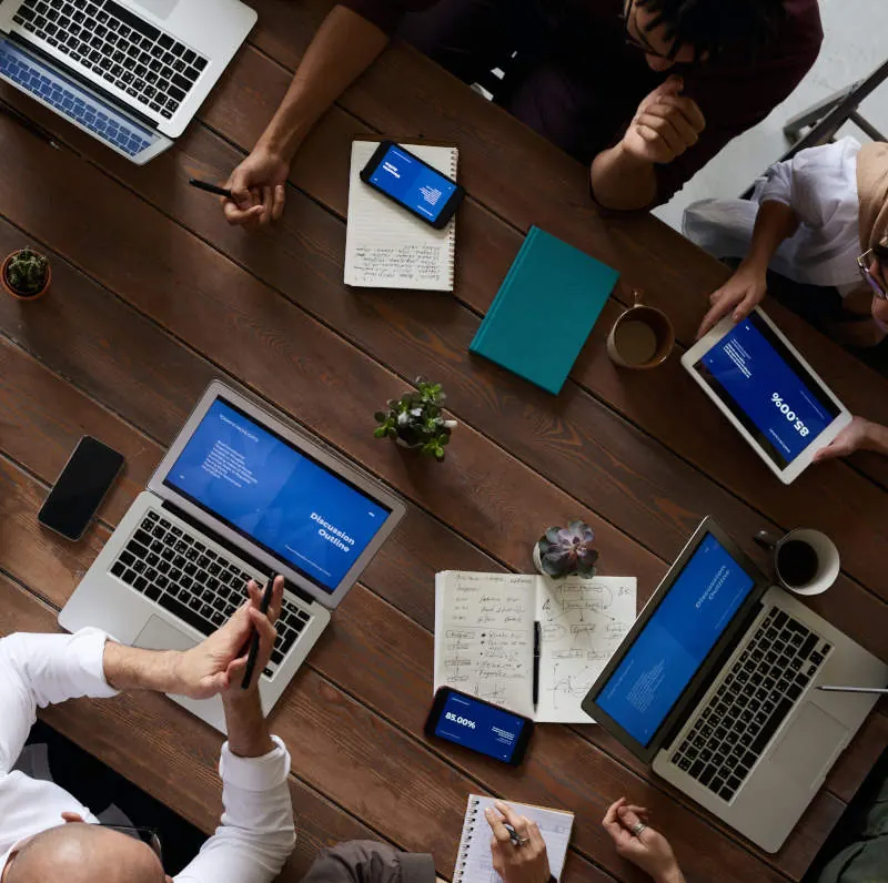 Equipo de trabajo revisando proyectos en laptops y tabletas